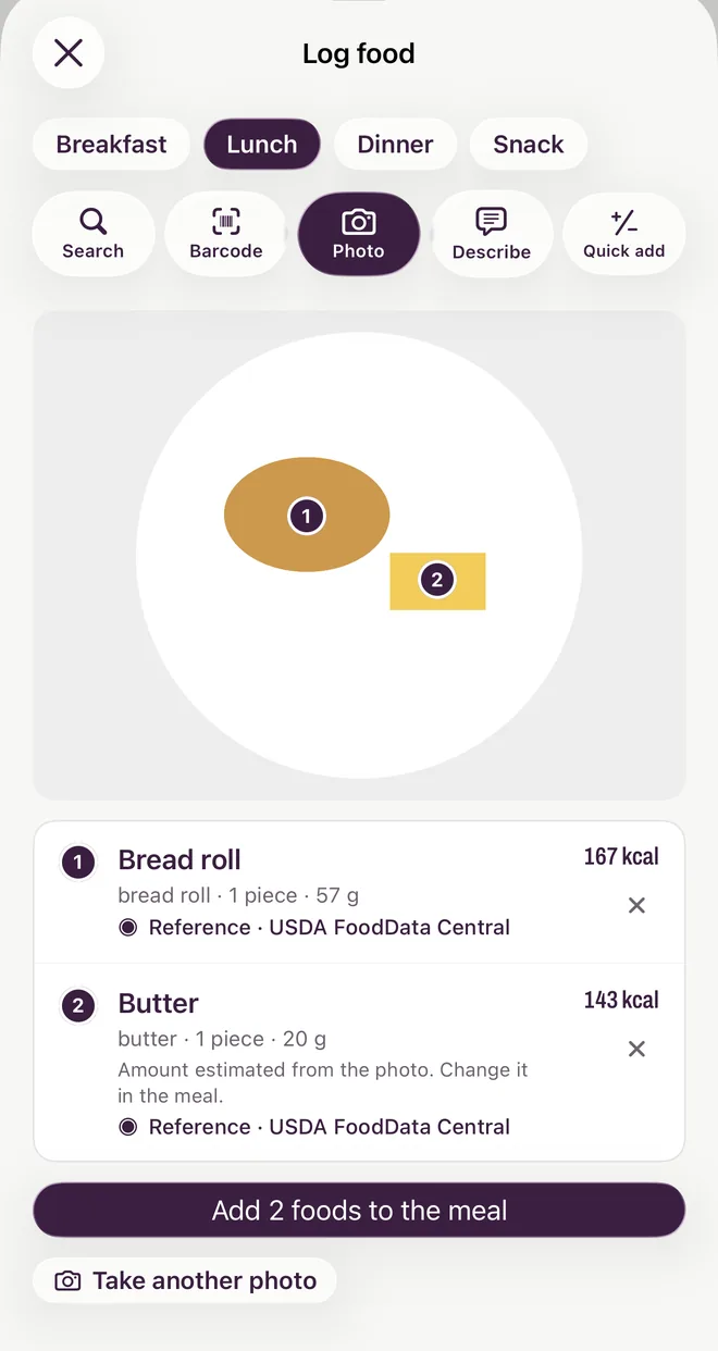 A meal photo in Yumta with two foods found, a bread roll and butter, each with a portion and the note that the amount was estimated from the photo.